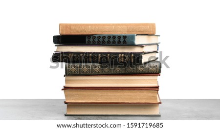 Stack of old vintage books on stone table against white background