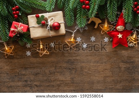 Holiday Christmas card background with festive decoration ball, stars, snowflakes, gift box, pine cones on a wood background from Flat lay, top view. Space for text Merry Christmas and happy New Year