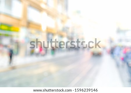 BLURRED CITY STREET BACKGROUND WITH BLUR OF PEOPLE WALKING, DEFOCUSED URBAN AREA IN CITYSCAPE