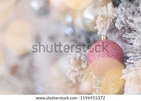 Decorated Christmas tree closeup. Silver and golden balls and illuminated garland with flashlights. New Year baubles macro photo with bokeh. Winter holiday light decoration