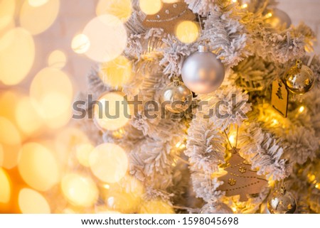 Christmas beautiful lights bokeh on gold warm background. Defocused Lights on a Tree Background. Christmas tree toys. Golden abstract blinking blurred.