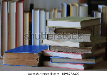 A close-up of a pile of old books on the table in the library Stacked books in the background selective focus and shallow depth of field