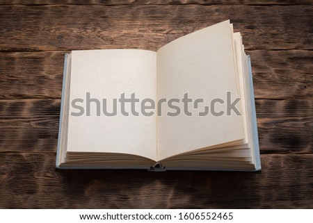 Open blank sheet book with copy space on brown wooden desk background.