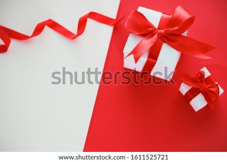 Valentine's day celebration concept. Gift with a red bow on a double white-red background with space for your text.