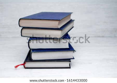 stack of books on wooden desk