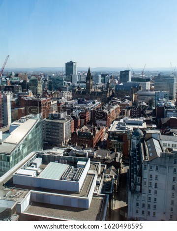 A skyline view of Manchester stretching for miles showing the town hall, central library and other iconic buildings on a bright and clear sunny day 
