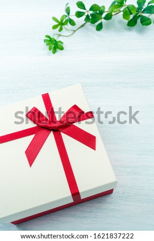 Gift box with ribbon on wooden table