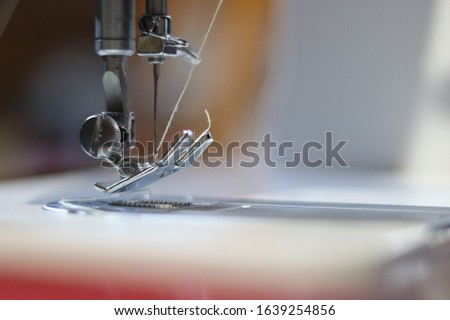 Sewing machine needle and thread closeup, equipment used to tailer, apparel industry equipment