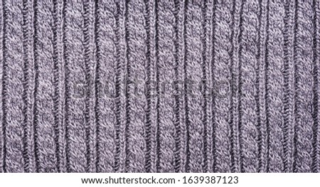 Gray knitted fabric texture close up. Can be used as a background. Selective focus