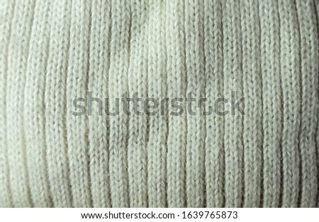 Knitted scarf close-up. Texture and background of knitted fabric. Warm winter material for sewing clothes.
