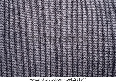 Fragment of knitted clothes in gray. Close-up. Top view