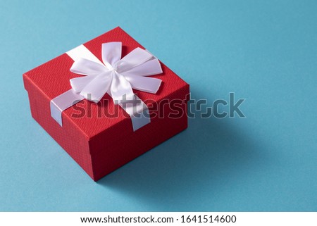 Valentine's Day celebration concept. A nice gift from a loved one. Box with a bow on a gentle blue background. Copy space. Flat lay.