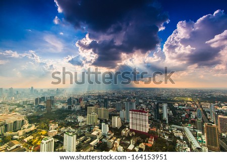 Rays of light shining through dark clouds city Bangkok, Thailand