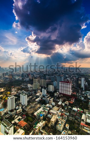 Rays of light shining through dark clouds city Bangkok, Thailand