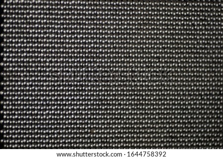 A metal surface consisting of round heads of nails.