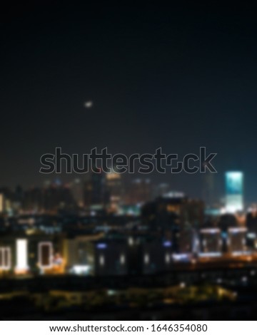 Blurred night view of a modern city, metropolis with skyscrapers and lighting. Abstract night light blur bokeh in the city background. City light blur bokeh, defocused background