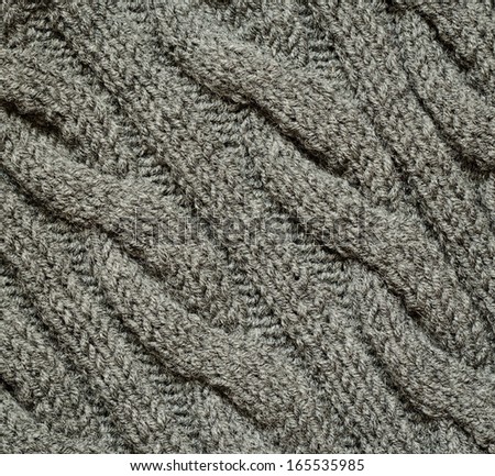 Gray knitted background with braids