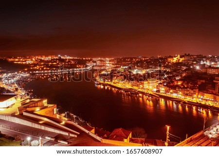 Night view of the mouth of the Douro River as it passes through the cities of Porto and Vila Nova de Gaia in Portugal.