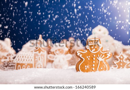 Macro photo of gingerbread village with falling snow