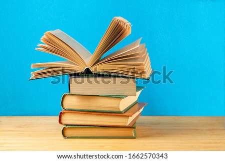 A stack of a book on the table on a blue background.Copy space.