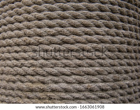 A wooden plank at the harbour wrapped in a thick ships rope