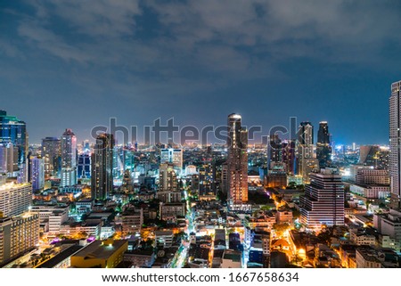 Cityscape of picturesque Bangkok at night time from rooftop. Panoramic evening skyline of the capital city of Thailand. The concept of metropolis.