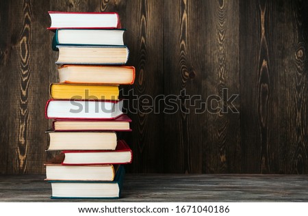 A stack of old books on a wooden background copy space.
