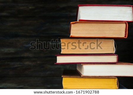 A stack of old books on a wooden background copy space.
