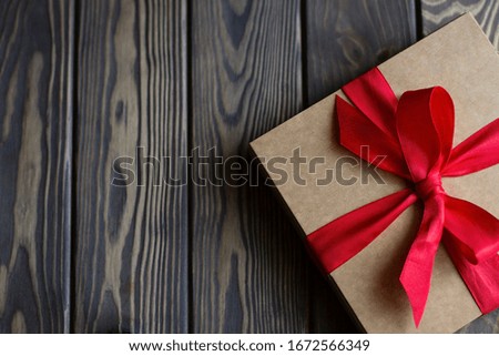 gift box with red ribbon on wooden background