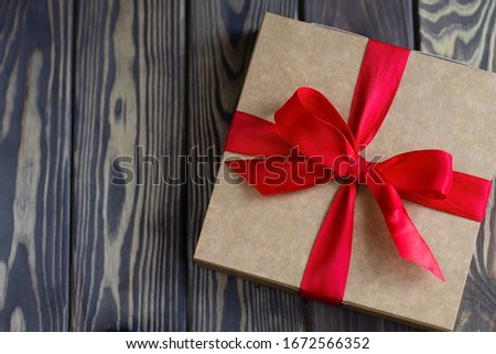 gift box with red ribbon on wooden background