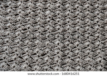 full frame of crocheting pattern in natural linen, dark background