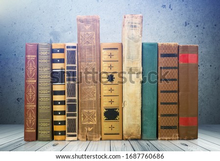 Collection of old books on a wooden desk