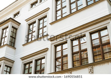White stoned building, classical architecture and wooden windows.