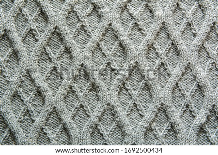 Grey knitted wool texture of a fabric with cable knit pattern