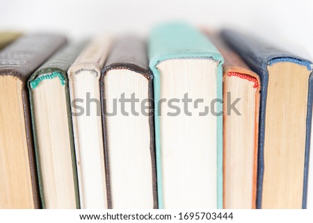 A stack of books on an isolated white background, the background of education, the concept of going back to school. A stack of colorful real books on a white background, partial view