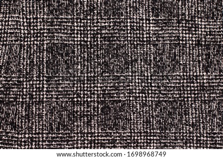Black and white cage texture fabric. Wool Background Texture. Coat close-up. Expensive women's coat. Textile warm dark knitted cloth background.