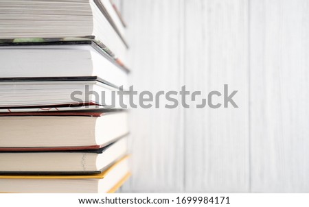 Book stack on white wooden table. Top view bright background of home library with space for text. World Book Day