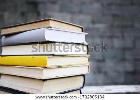 Books on a wooden bench in front of a wall