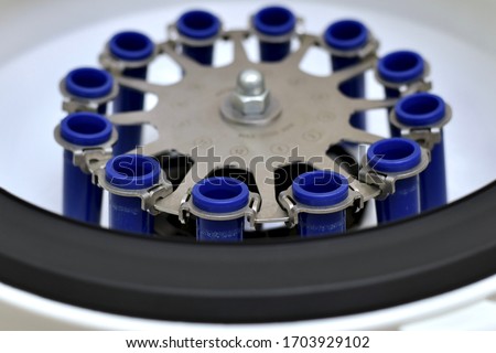 Working scratched centrifuge with partially blurred pockets for test tubes.