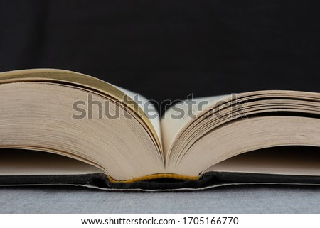 An open book lying on a table with a background.