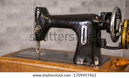 Close up of old manual sewing machine on table.
