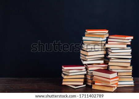 many stacks of educational books in the university library on a black background