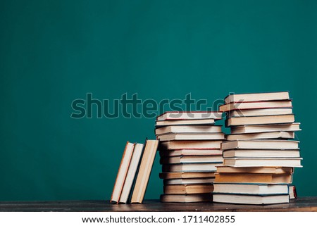 many stacks of educational books in the university library on a green background