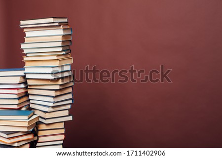 a lot of stacks of educational books in the college library on a brown background