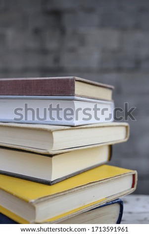 Books on a wooden bench in front of a wall