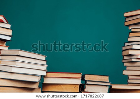 lots of stacks of educational books to teach in the school library on a green background