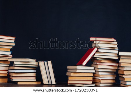 many stacks of educational books for college exams in the library on a black background