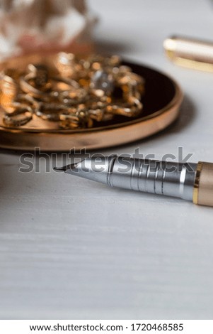 Golden accessories and pen, close up. 