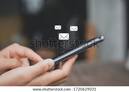 Woman hand using smart phone at coffee shop with email icon flying abstract background. Technology business and freelance concept. Vintage tone filter effect color style.