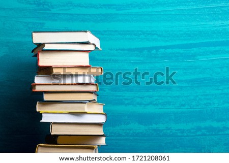 Composition with vintage old hardback books, diary, fanned pages on wooden deck table and red background. Books stacking. Back to school. Copy Space. Education background.